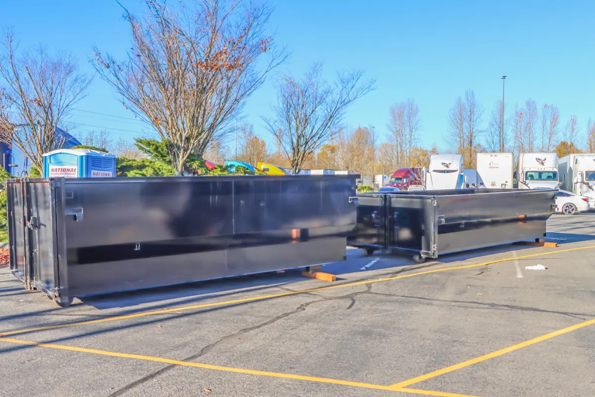 Professional dumpster rental service with roll-off container on residential driveway in Holden